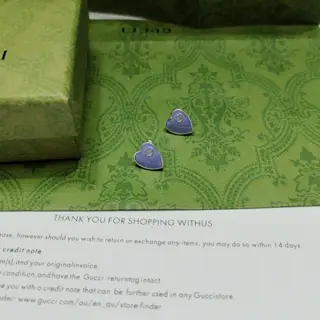This pair of GUcci earrings features a heart-shaped background