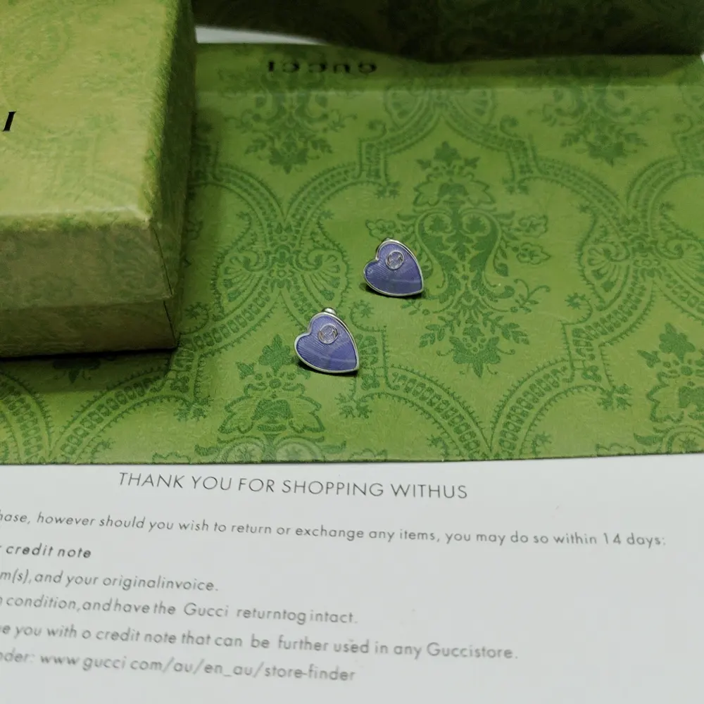 This pair of GUcci earrings features a heart-shaped background