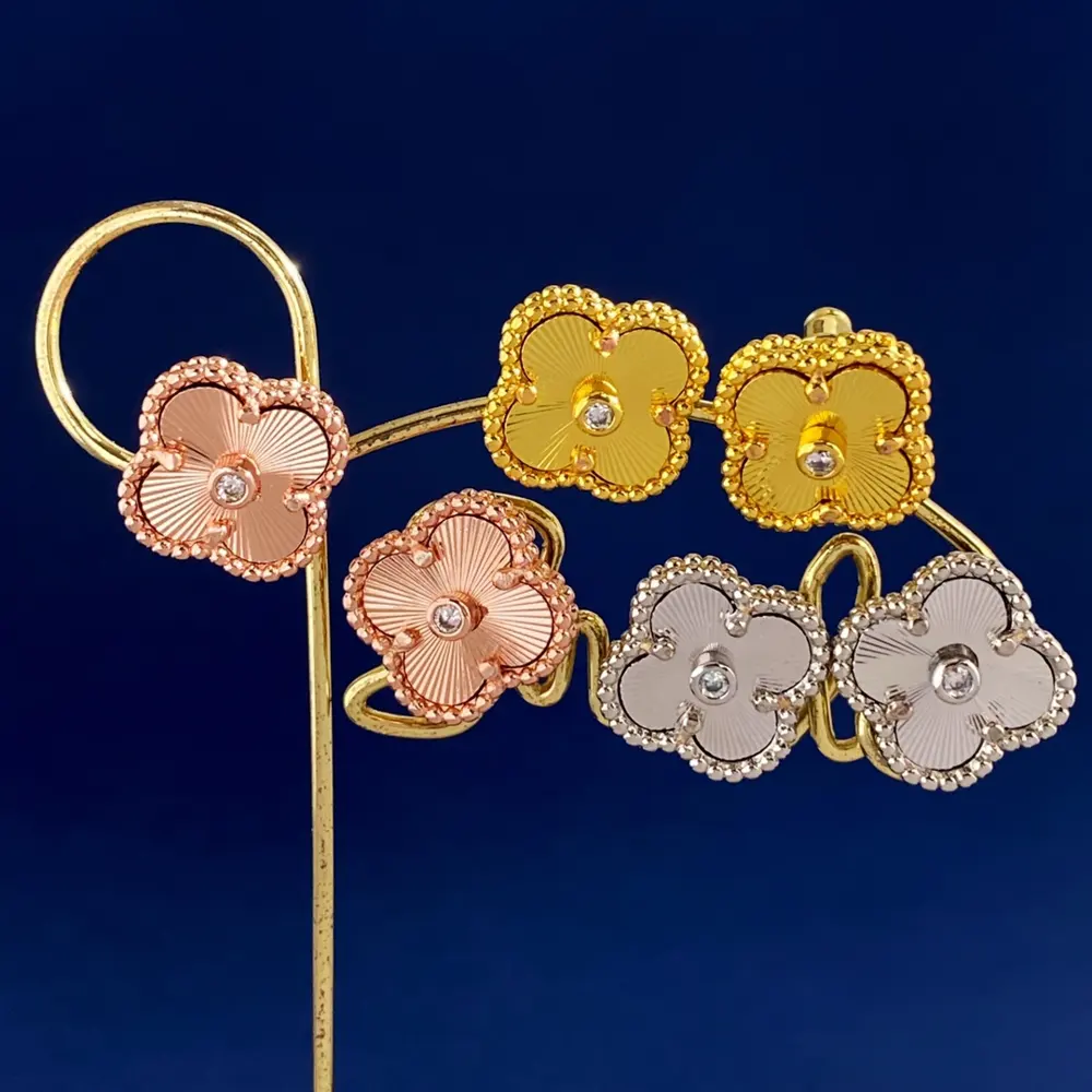 Van Cleef & Arpels simple brushed metal with a single diamond and lucky four-leaf clover