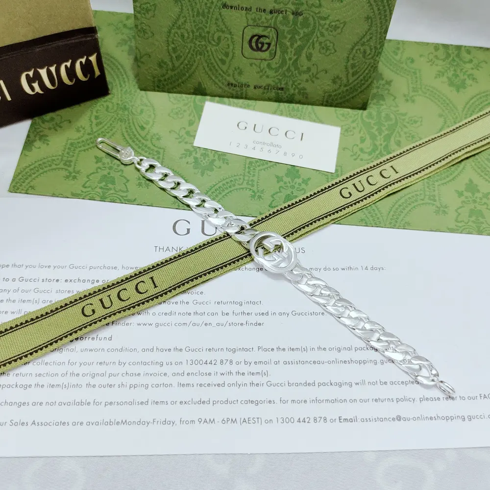 This Gucci bracelet is decorated with two Cuban plain chains and a brand image in the middle