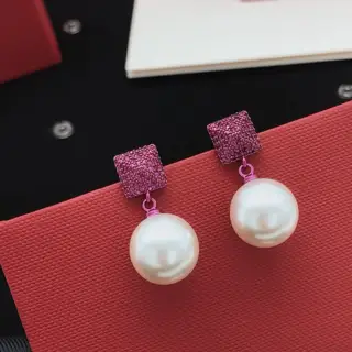 Valentino earrings with squares and triangles forming a purple diamond-studded pearl