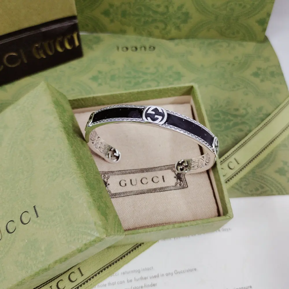 GUcci’s monogrammed bracelet is reinterpreted as a unique interlocking double G shape. The